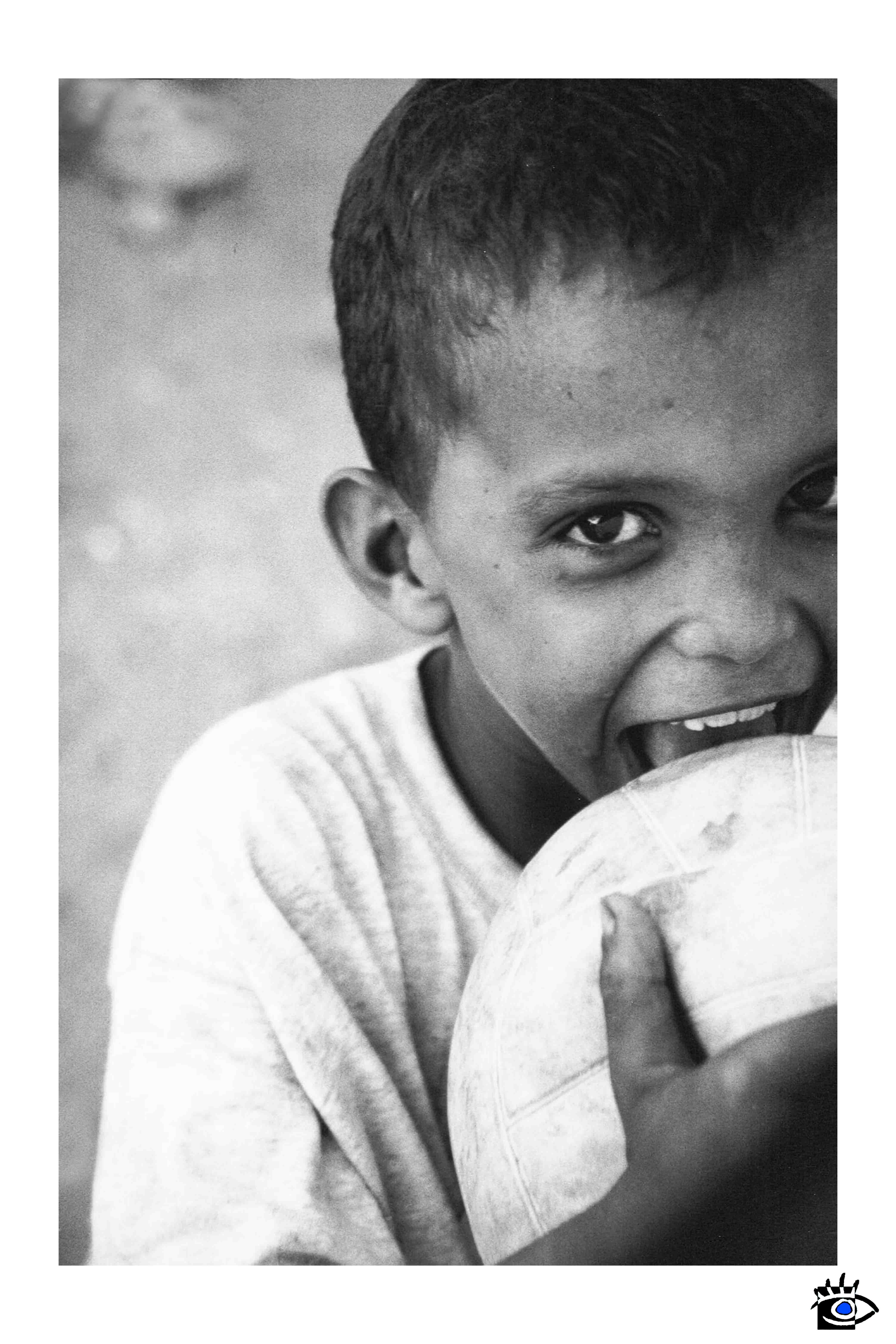 Un bambino keniano, visibilmente triste, stringe una palla tra le mani in una scena malinconica