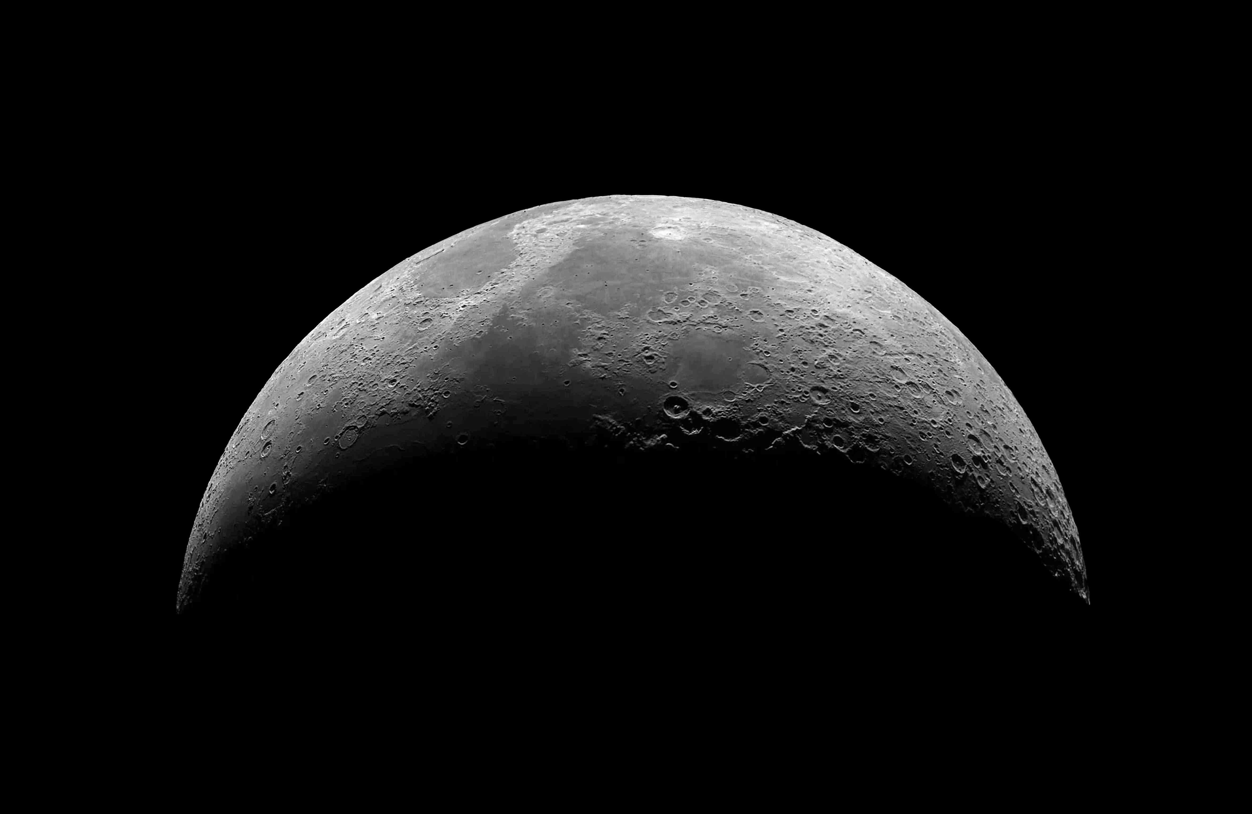 Immagine della Luna nella fase crescente ripresa con obiettivo Canon EF 400mm f/4 L USM, mostrando i dettagli dei crateri e delle caratteristiche della superficie lunare.