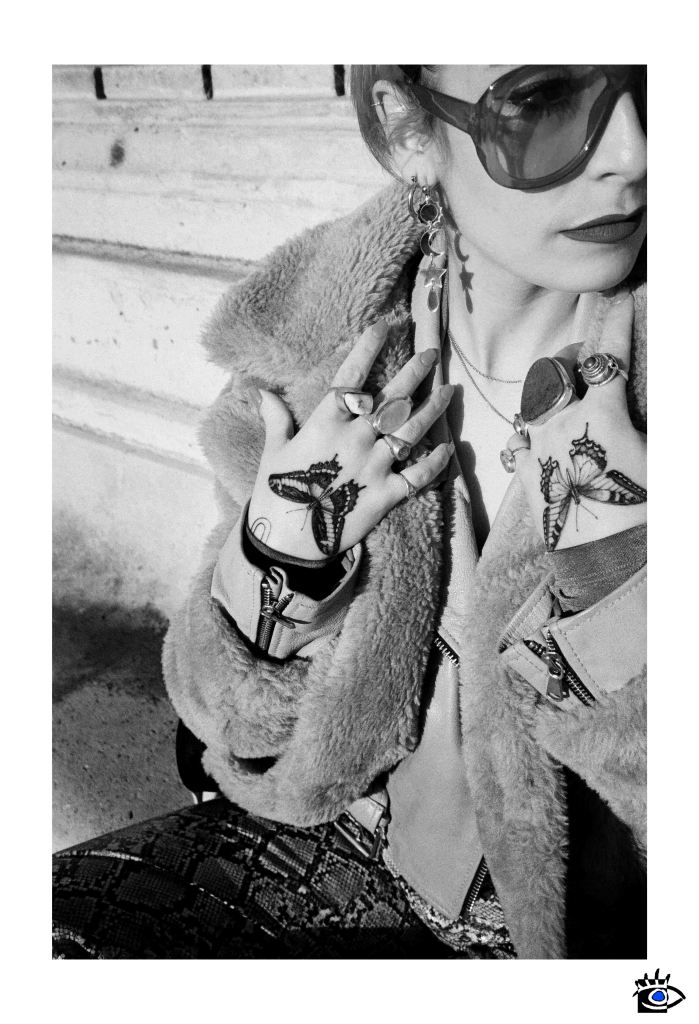 Una riflessione sulla fotografia analogica e digitale attraverso il ritratto di una giovane donna tatuata, scattato in Piazza Garibaldi a Parma. L'articolo esplora le differenze tra l’autenticità dell’immagine reale e l'interpretazione dell'intelligenza artificiale, analizzando come il significato e i dettagli vengano reinterpretati nella versione digitale. Un confronto tra realtà e tecnologia nell'arte fotografica.