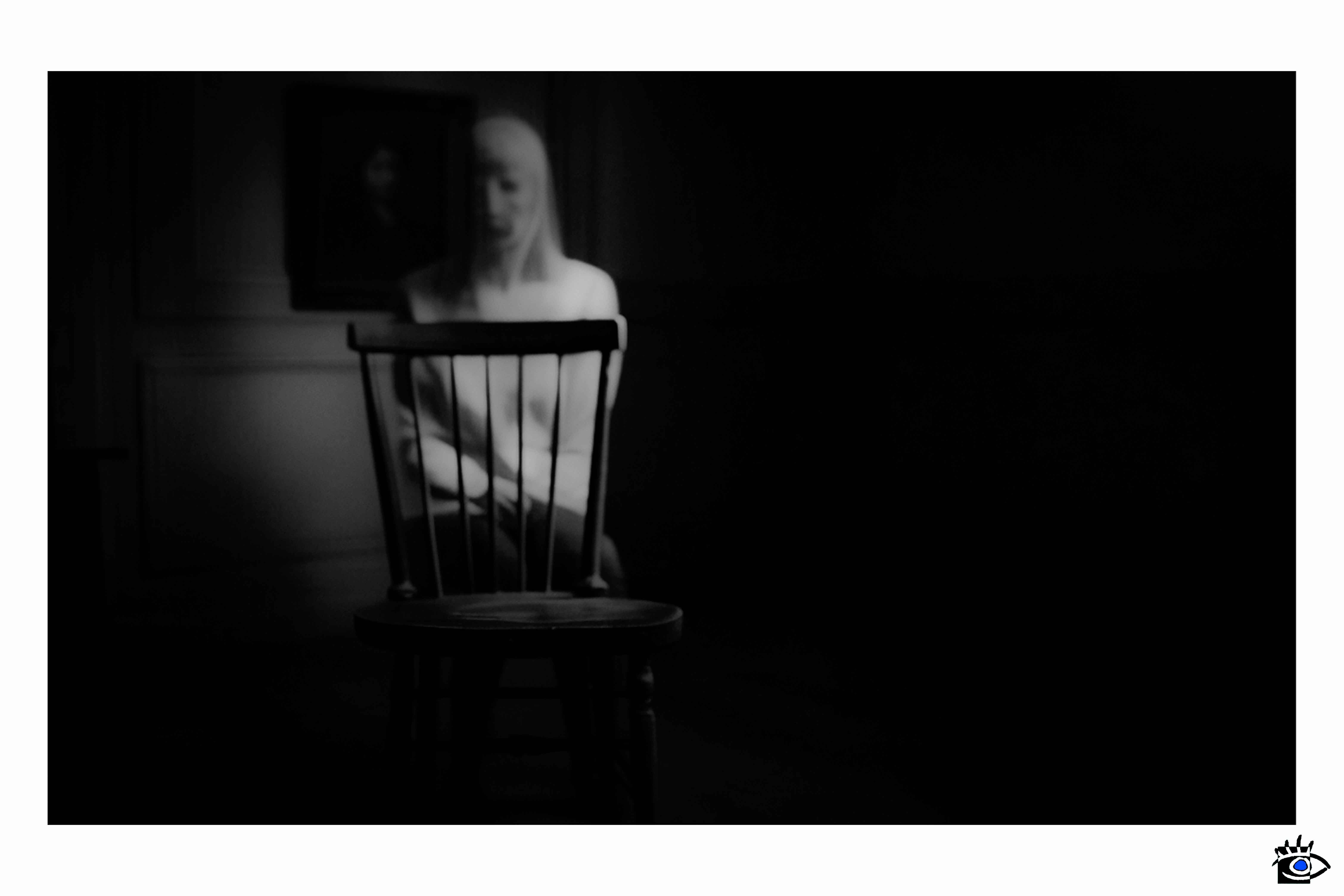 Ethereal shape behind unoccupied chair.