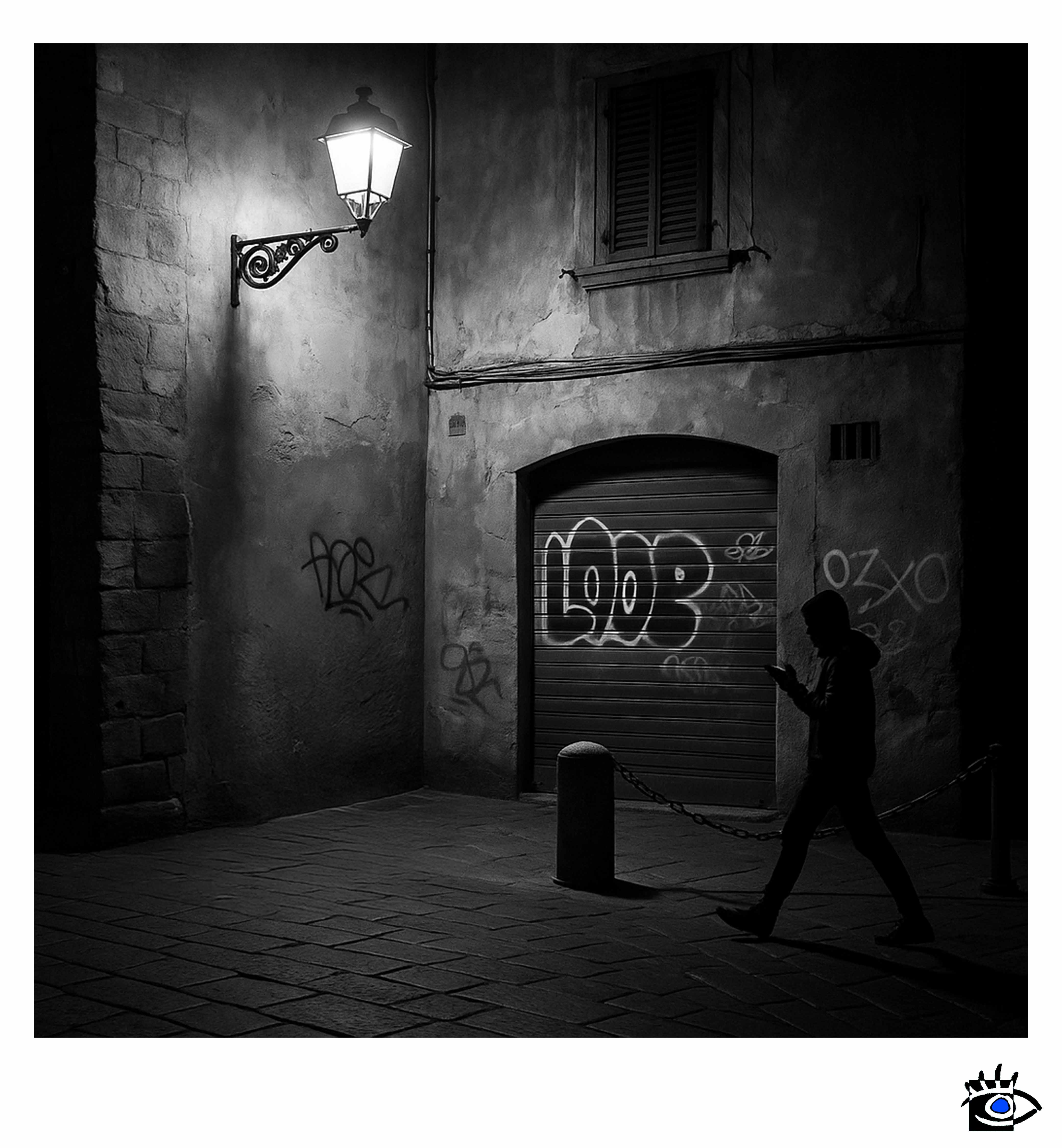 Un momento trattenuto nella penombra, dove la vita scorre senza chiedere permesso. Una presenza solitaria che attraversa un luogo già stanco di essere visto.